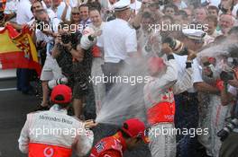 27.05.2007 Monte Carlo, Monaco,  Team and photographers in the spray of the champaign from Fernando Alonso (ESP), McLaren Mercedes and Lewis Hamilton (GBR), McLaren Mercedes - Formula 1 World Championship, Rd 5, Monaco Grand Prix, Sunday Podium