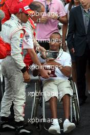 27.05.2007 Monte Carlo, Monaco,  Nicholas Hamilton (GBR), Brother of Lewis Hamilton gets the trophy from Ron Dennis (GBR), McLaren, Team Principal, Chairman dirkt after the Podium ceremony - Formula 1 World Championship, Rd 5, Monaco Grand Prix, Sunday Podium