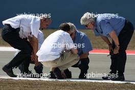 24.08.2007 Istanbul, Turkey,  Track workers and the FIA try to repair a drain cover which came loose during the session - Formula 1 World Championship, Rd 12, Turkish Grand Prix, Friday Practice