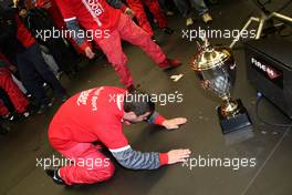 26.10.2008 Hockenheim, Germany,  After the victory of Timo Scheider (GER), Audi Sport Team Abt, Audi A4 DTM a privat party started in the Abt pitbox with a band, dancing technicians and champagne and beer! And a technician worshipping the victory trophy. - DTM 2008 at Hockenheimring, Germany