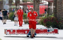 03.04.2008 Sakhir, Bahrain,  Scuderia Ferrari team member carrying freight into the paddock - Formula 1 World Championship, Rd 3, Bahrain Grand Prix, Thursday