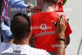 08.06.2008 Montreal, Canada,  Lewis Hamilton (GBR), McLaren Mercedes signs a boys t-shirt - Formula 1 World Championship, Rd 7, Canadian Grand Prix, Sunday