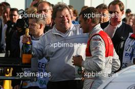 25.10.2009 Hockenheim, Germany,  Norbert Haug (GER), Sporting Director Mercedes-Benz, congratulates 2009 DTM champion Timo Scheider (GER), Audi Sport Team Abt, by handing over a special bottle of champaign - DTM 2009 at Hockenheimring, Hockenheim, Germany