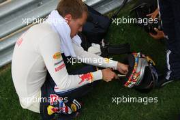 26.04.2009 Manama, Bahrain, Sebastian Vettel (GER), Red Bull Racing cutting something on his helmet - Formula 1 World Championship, Rd 4, Bahrain Grand Prix, Sunday Pre-Race Grid