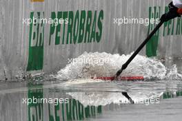 17.10.2009 Sao Paulo, Brazil,  Mechanics sweep away the water from the pitlane - Formula 1 World Championship, Rd 16, Brazilian Grand Prix, Saturday Practice