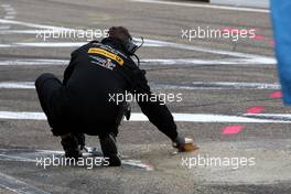 21.08.2010 Zandvoort, The Netherlands,  Mercedes Benz mechanic cleaning fresh concrete in the pitlane. Already after a few minutes in the session the fresh concrete let lose and damaged tyres. - DTM 2010 at Circuit Park Zandvoort, The Netherlands