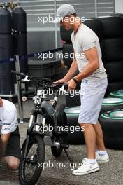 22.07.2010 Mannheim, Germany,  Michael Schumacher (GER), Mercedes GP Petronas with his electric bike - Formula 1 World Championship, Rd 11, German Grand Prix, Thursday