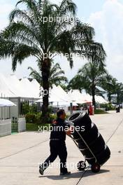 01.04.2010 Kuala Lumpur, Malaysia,  Toro Rosso Mechanic in the paddock pushing tyres - Formula 1 World Championship, Rd 3, Malaysian Grand Prix, Thursday
