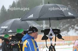 13.01.2011, Ruhpolding, Germany (GER): Gerald Hoenig (GER), Coach Team Germany, Ricco Gross (GER) Coach Team Germany and Staffan Eklund (SWE), coach Sweden wait under the umbrellas - IBU world cup biathlon, individual women, Ruhpolding (GER). www.xpb.cc. © Manzoni/xpb.cc. Every downloaded picture is fee-liable.