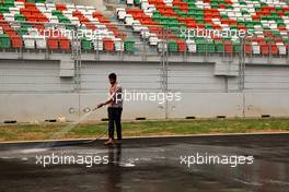 26.10.2011 New Delhi, India, A man washes the track - Formula 1 World Championship, Rd 17, Indian Grand Prix, Wednesday