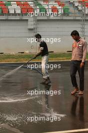 26.10.2011 New Delhi, India, Track atmosphere, a man cleans the track  - Formula 1 World Championship, Rd 17, Indian Grand Prix, Wednesday