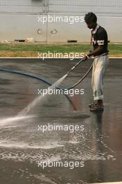 26.10.2011 New Delhi, India, Track atmosphere, a man cleans the track - Formula 1 World Championship, Rd 17, Indian Grand Prix, Wednesday