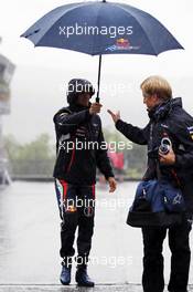 Sebastian Vettel (GER) Red Bull Racing and Heikki Huovinen (FIN) Personal Trainer during a heavy rain shower. 31.08.2012. Formula 1 World Championship, Rd 12, Belgian Grand Prix, Spa Francorchamps, Belgium, Practice Day