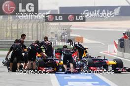 (L to R): Mark Webber (AUS) Red Bull Racing RB8 and Sebastian Vettel (GER) Red Bull Racing RB8 pushed back in the pits. 20.04.2012. Formula 1 World Championship, Rd 4, Bahrain Grand Prix, Sakhir, Bahrain, Practice Day