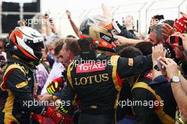 Romain Grosjean (FRA) Lotus F1 Team celebrates his third position in parc ferme with the team. Motor Racing - Formula One World Championship - Bahrain Grand Prix - Race Day - Sakhir, Bahrain