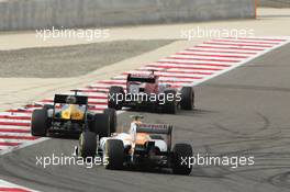 Daniel Ricciardo (AUS) Scuderia Toro Rosso STR7 leads Vitaly Petrov (RUS) Caterham CT01 and Nico Hulkenberg (GER) Sahara Force India F1 VJM05. Motor Racing - Formula One World Championship - Bahrain Grand Prix - Race Day - Sakhir, Bahrain