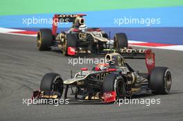 Romain Grosjean (FRA) Lotus F1 E20 lesds team mate Kimi Raikkonen (FIN) Lotus E20. Motor Racing - Formula One World Championship - Bahrain Grand Prix - Race Day - Sakhir, Bahrain