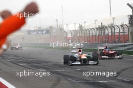 Paul di Resta (GBR) Sahara Force India VJM05 finishes sixth ahead of Fernando Alonso (ESP) Ferrari F2012 and celebrates past his team at the end of the race. Motor Racing - Formula One World Championship - Bahrain Grand Prix - Race Day - Sakhir, Bahrain