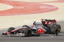 Jenson Button (GBR) McLaren MP4/27 and Kimi Raikkonen (FIN) Lotus E20. Motor Racing - Formula One World Championship - Bahrain Grand Prix - Race Day - Sakhir, Bahrain