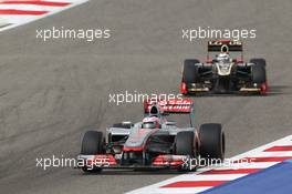 Jenson Button (GBR) McLaren MP4/27 leads Kimi Raikkonen (FIN) Lotus E20. Motor Racing - Formula One World Championship - Bahrain Grand Prix - Race Day - Sakhir, Bahrain