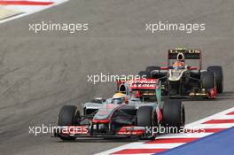 Lewis Hamilton (GBR) McLaren MP4/27 leads Romain Grosjean (FRA) Lotus F1 E20. Motor Racing - Formula One World Championship - Bahrain Grand Prix - Race Day - Sakhir, Bahrain