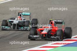 Charles Pic (FRA) Marussia F1 Team MR01 leads Michael Schumacher (GER) Mercedes AMG F1 W03. Motor Racing - Formula One World Championship - Bahrain Grand Prix - Race Day - Sakhir, Bahrain