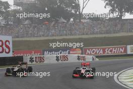Kimi Raikkonen (FIN) Lotus F1 E20 and Jenson Button (GBR) McLaren MP4/27. 25.11.2012. Formula 1 World Championship, Rd 20, Brazilian Grand Prix, Sao Paulo, Brazil, Race Day.