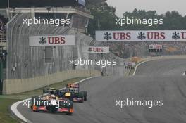 Narain Karthikeyan (IND) HRT Formula One Team HRT F112 leads Sebastian Vettel (GER) Red Bull Racing RB8. 25.11.2012. Formula 1 World Championship, Rd 20, Brazilian Grand Prix, Sao Paulo, Brazil, Race Day.