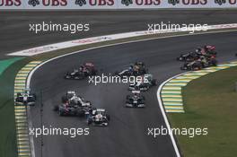 Sebastian Vettel (GER) Red Bull Racing RB8 survives a crash with Bruno Senna (BRA) Williams FW34 and Sergio Perez (MEX) Sauber C31 at the start of the race. 25.11.2012. Formula 1 World Championship, Rd 20, Brazilian Grand Prix, Sao Paulo, Brazil, Race Day.