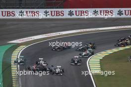 Sebastian Vettel (GER) Red Bull Racing RB8 survives a crash with Bruno Senna (BRA) Williams FW34 and Sergio Perez (MEX) Sauber C31 at the start of the race. 25.11.2012. Formula 1 World Championship, Rd 20, Brazilian Grand Prix, Sao Paulo, Brazil, Race Day.