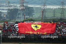 Large Ferrari banner with the fans in the grandstand.