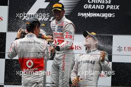 (L to R): second placed Jenson Button (GBR) McLaren celebrates with team mate Lewis Hamilton (GBR) McLaren and race winner Nico Rosberg (GER) Mercedes AMG F1 the champagne on the podium. 15.04.2012. Formula 1 World Championship, Rd 3, Chinese Grand Prix, Shanghai, China, Race Day