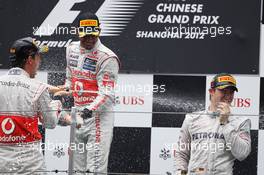 (L to R): second placed Jenson Button (GBR) McLaren celebrates with team mate Lewis Hamilton (GBR) McLaren and race winner Nico Rosberg (GER) Mercedes AMG F1 the champagne on the podium. 15.04.2012. Formula 1 World Championship, Rd 3, Chinese Grand Prix, Shanghai, China, Race Day