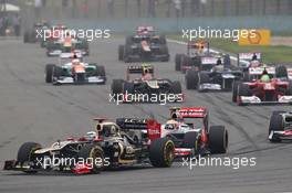 Romain Grosjean (FRA) Lotus F1 E20 leads Lewis Hamilton (GBR) McLaren MP4/27 at the start of the race. 15.04.2012. Formula 1 World Championship, Rd 3, Chinese Grand Prix, Shanghai, China, Race Day