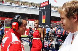 Sebastian Vettel (GER) Red Bull Racing passes Hirohide Hamashima (JPN) Ferrari Tyre Engineer on the grid. 10.05.2012. Formula 1 World Championship, Rd 5, Spanish Grand Prix, Barcelona, Spain, Race Day