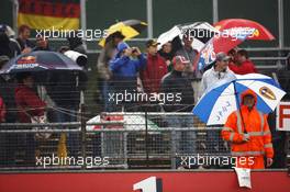 Fans and marshals brave the rain in the grandstands. 06.07.2012. Formula 1 World Championship, Rd 9, British Grand Prix, Silverstone, England, Practice Day