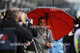 Lewis Hamilton (GBR) McLaren walks through the pits with an umbrella. 06.07.2012. Formula 1 World Championship, Rd 9, British Grand Prix, Silverstone, England, Practice Day
