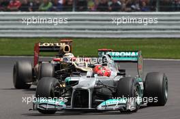 Michael Schumacher (GER) Mercedes AMG F1 W03 leads Kimi Raikkonen (FIN) Lotus F1 E20. 08.07.2012. Formula 1 World Championship, Rd 9, British Grand Prix, Silverstone, England, Race Day