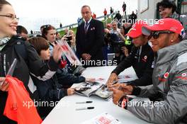 Lewis Hamilton (GBR) McLaren and Jenson Button (GBR) McLaren sign autographs for the fans. 07.07.2012. Formula 1 World Championship, Rd 9, British Grand Prix, Silverstone, England, Qualifying Day