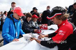Charles Pic (FRA) Marussia F1 Team signs autographs for the fans. 07.07.2012. Formula 1 World Championship, Rd 9, British Grand Prix, Silverstone, England, Qualifying Day