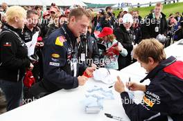 Sebastian Vettel (GER) Red Bull Racing signs autographs for the fans. 07.07.2012. Formula 1 World Championship, Rd 9, British Grand Prix, Silverstone, England, Qualifying Day