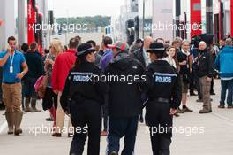 Police escort an unauthorised person in the paddock. 08.07.2012. Formula 1 World Championship, Rd 9, British Grand Prix, Silverstone, England, Race Day