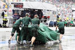 A covered Caterham CT01 is pushed down the pit lane as the rain falls heavily. 21.07.2012. Formula 1 World Championship, Rd 10, German Grand Prix, Hockenheim, Germany, Qualifying Day