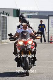 Jenson Button (GBR) McLaren arrrives at the circuit on a motorbike with Mike Collier (GBR) Personal Trainer. 22.07.2012. Formula 1 World Championship, Rd 10, German Grand Prix, Hockenheim, Germany, Race Day