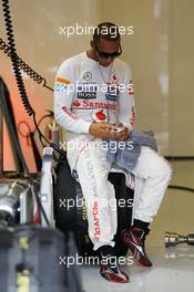 Lewis Hamilton (GBR) McLaren MP4/27 on his mobile phone in the pits. 27.07.2012. Formula 1 World Championship, Rd 11, Hungarian Grand Prix, Budapest, Hungary, Practice Day