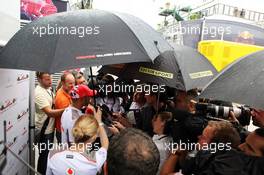 Lewis Hamilton (GBR) McLaren with the media in the rain. 26.07.2012. Formula 1 World Championship, Rd 11, Hungarian Grand Prix, Budapest, Hungary, Preparation Day