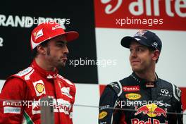 (L to R): Fernando Alonso (ESP) Ferrari with race winner Sebastian Vettel (GER) Red Bull Racing on the podium. 28.10.2012. Formula 1 World Championship, Rd 17, Indian Grand Prix, New Delhi, India, Race Day.