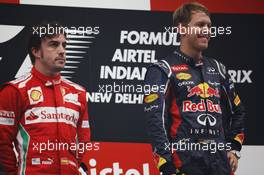 Race winner Sebastian Vettel (GER) Red Bull Racing on the podium with Fernando Alonso (ESP) Ferrari. 28.10.2012. Formula 1 World Championship, Rd 17, Indian Grand Prix, New Delhi, India, Race Day.