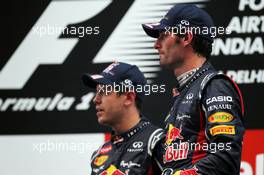Mark Webber (AUS) Red Bull Racing and race winner Sebastian Vettel (GER) Red Bull Racing on the podium. 28.10.2012. Formula 1 World Championship, Rd 17, Indian Grand Prix, New Delhi, India, Race Day.