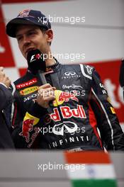Race winner Sebastian Vettel (GER) Red Bull Racing on the podium. 28.10.2012. Formula 1 World Championship, Rd 17, Indian Grand Prix, New Delhi, India, Race Day.